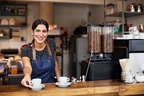 istock Confident barista with coffee cup at counter 1200971545