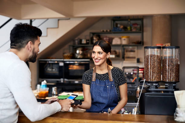 istock Businessman paying barista through cellphone 1200971566