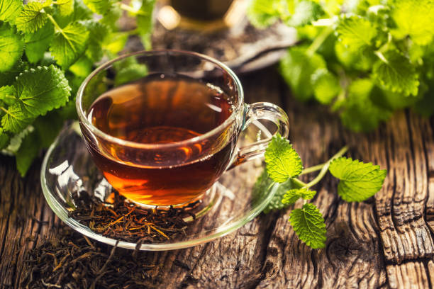 istock A cup of melissa tea with herbs on wooden table 1200972772