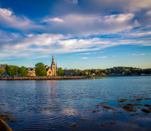 l'église réfléchit dans l'eau dans la baie de mahone - mahone bay photos et images de collection