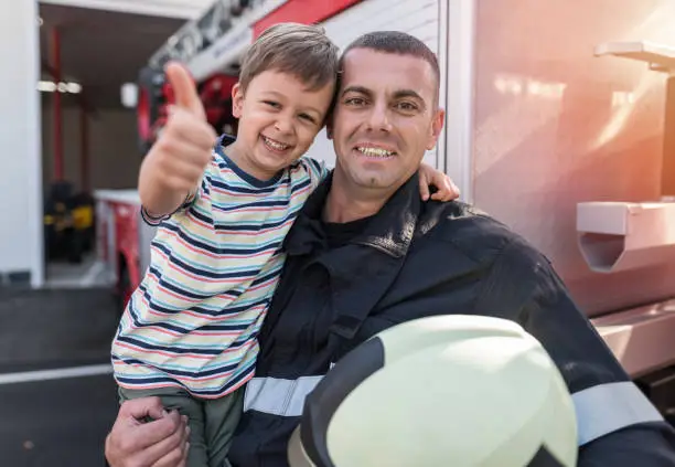 Photo of Cheerful little boy visiting the firefighters