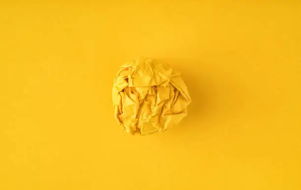 Photo of Crumpled paper on yellow background