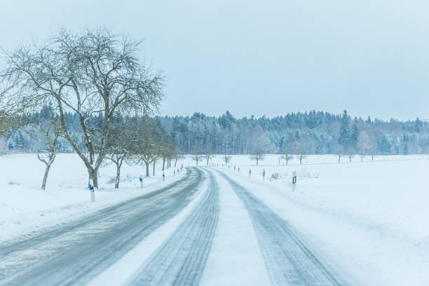 tráfego solitário de estrada de inverno gelada com pista branca de neve - car winter road reflector snow - fotografias e filmes do acervo