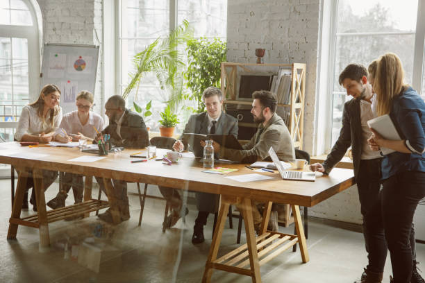 istock Group of young business professionals having a meeting, creative office 1200978644