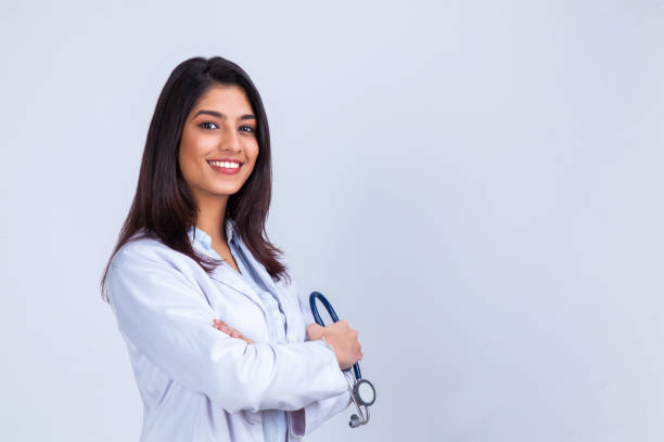 medical concept of asian beautiful female doctor in white coat with stethoscope, waist up. medical student. woman hospital worker looking at camera and smiling, studio, gray background - aside imagens e fotografias de stock