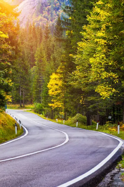 Photo of Mountain road. Landscape with rocks, sunny sky with clouds and beautiful asphalt road in the evening in summer. Vintage toning. Travel background. Highway in mountains.