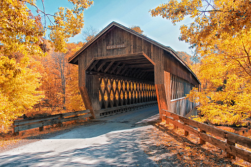 A bright red wooden covered bridge outside Woodstock, Vermont  on an October morning.