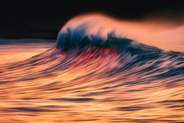 istock wave with spray breaking at sunset with in camera panning technique 1200982171