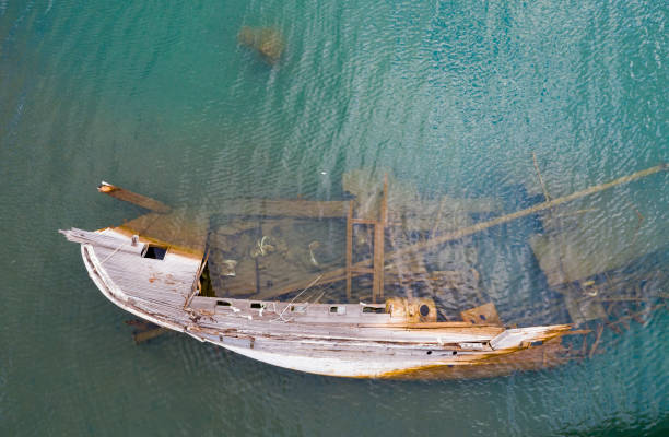 Old boat Sunken boat in sea Taken via drone. fishing boat sinking stock pictures, royalty-free photos & images