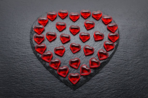 istock valentines day background with red hearts on black 1200986038