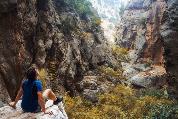 istock A traveler in unity with nature, a young man sits on a rock 1200987606