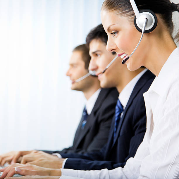 Three support phone operators at workplace stock photo