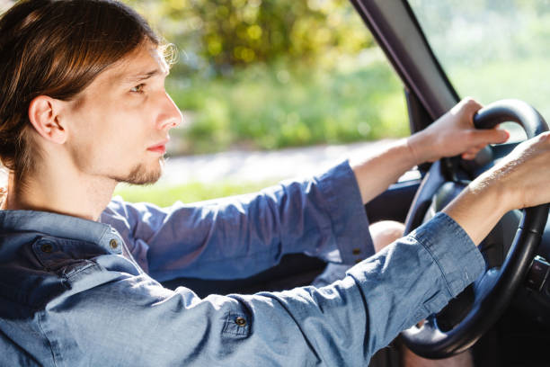 istock Young man with long hair driving car 1200991522