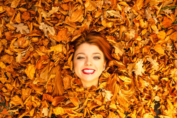 istock Beautiful young lady is lying between leaves. 1200993188