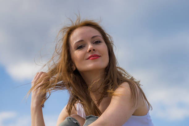 istock Brown long hair blowing in the wind against sky. 1200993322