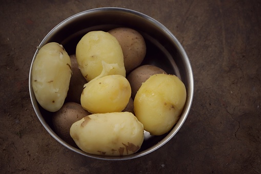 Boiled Potatoes in a Steel Bowl Isolated on Soil Floor, Kitchen of Rural India.
