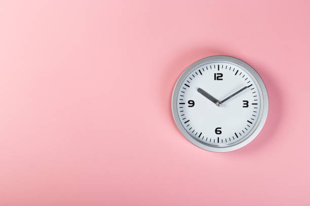 istock minimalistic white wall clock with light metal on a pink background. time concept. 1200997766