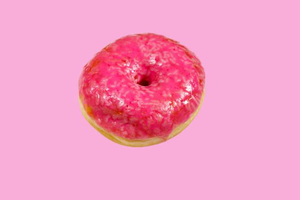 istock Tasty pink donut on pink background 1200998131