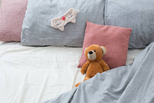 istock bed with teddy bear on gray linens 1201000252
