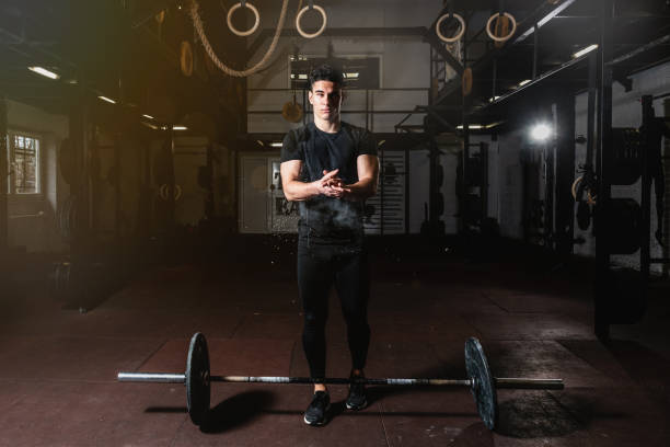Young fit muscular guy preparing putting sport chalk on his hands for heavy cross weightlifting or deadlifting workout training in the gym Dead lift workout, Young fit muscular guy preparing putting sport chalk on his hands for heavy cross weightlifting or deadlifting workout training in the gym crossfit chalk weightlifting weight training stock pictures, royalty-free photos & images