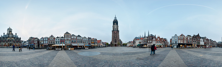 360 degrees Panorama of the market in Delft. The Nieuwe Kerk stands on the market square where the members of the royal family are buried. At the church stands the statue of Hugo de Groot. Opposite the Nieuwe Kerk stands the town hall. People are walking in the square.
