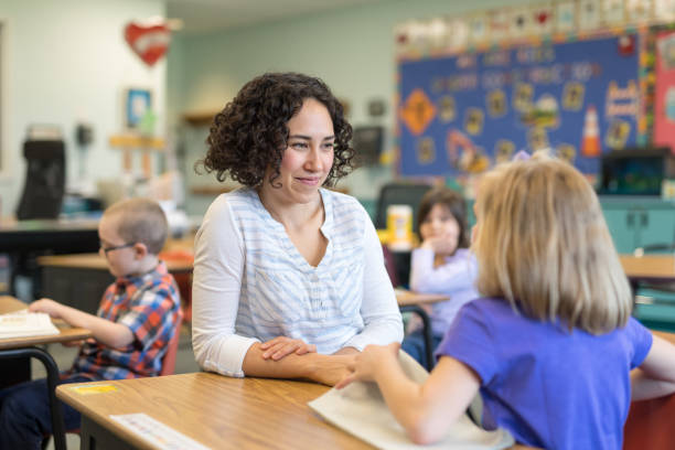 istock A first grade teacher talking with one of her students in the classroom 1201002525