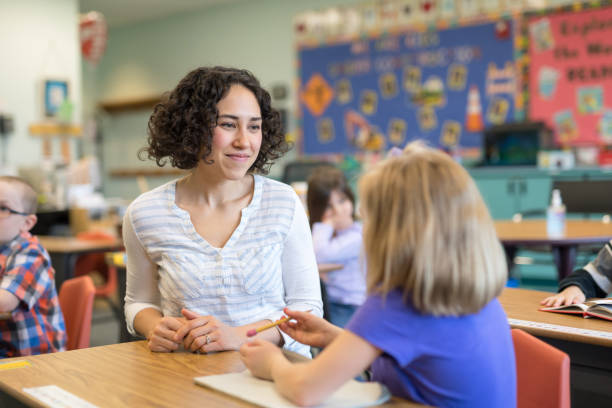 istock A first grade teacher talking with one of her students in the classroom 1201002529