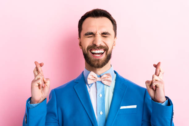 istock bearded man in suit with crossed fingers on pink 1201003499