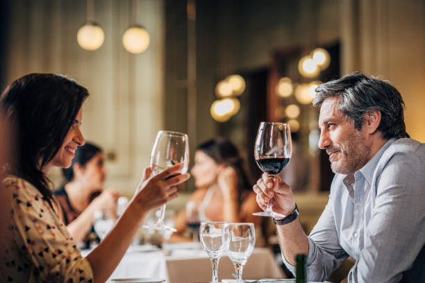 mature couple on a date - restaurant wine table table for two imagens e fotografias de stock