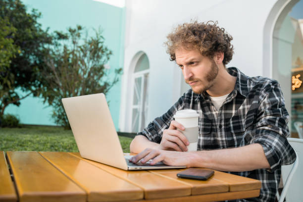 istock Young man using his laptop in a coffee shop. 1201005539