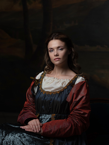 Portrait of a young woman in the style of a Renaissance painting. Beautiful mysterious girl in medieval dress