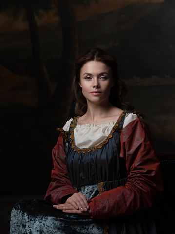 Portrait of a young woman in the style of a Renaissance painting. Beautiful mysterious girl in medieval dress
