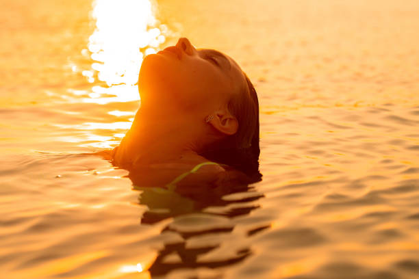 istock young lady in the sea at warm sunset 1201008331