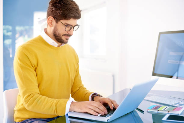 istock Confident casual businessman using his notebook in the office 1201008811