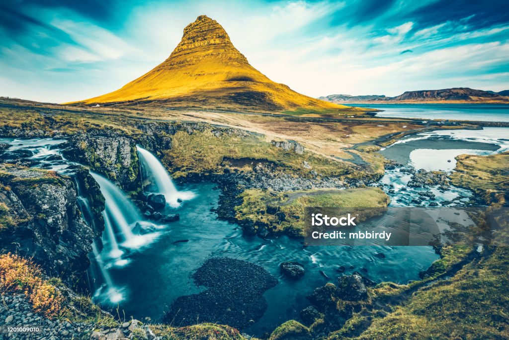 Kirkjufellsfoss waterfall with Kirkjufell mountain, Iceland Kirkjufellsfoss waterfall with Kirkjufell mountain (463 m high), located on on Snæfellsnes peninsula, the region in western Iceland. Waterfall Stock Photo