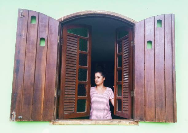 Little cute girl, kid peeking out green door with and to forehead. Playful mood, having fun. Curious kid looking with attention. Concept of childhood, emotions, facial expression, lifestyle
