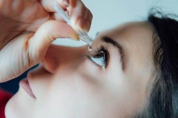 woman putting eye drops woman putting eye drops eyedropper stock pictures, royalty-free photos & images