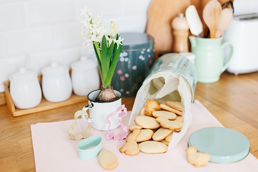 Baked easter cookies in metal container on wooden table in the kitchen. Spring decoration