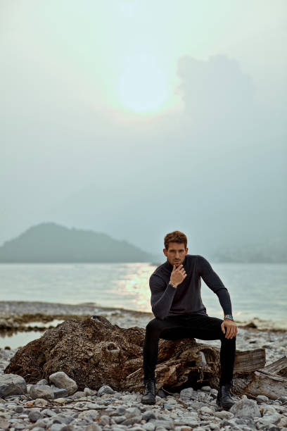 Handsome man relaxing on the beach near the lake