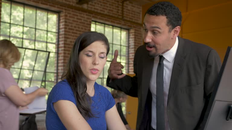 Female employee looks away from her multi ethnic boss yelling at her