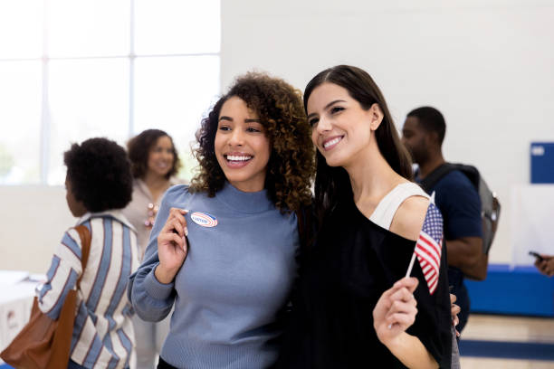 istock Two friends stand together and smile after voting 1201018742