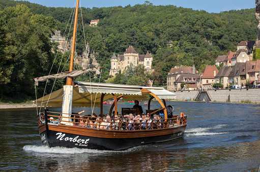 La Roque-Gageac, Dordogne, France - September 7, 2018: A tourist boat, in French called gabare, on the river Dordogne at La Roque-Gageac, Aquitaine, France