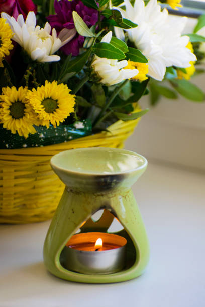 Oil burner with chrysanthemums by the side. Aromatherapy burner. Oil, aromatherapy burner, flowers and candles for spa and relaxation.