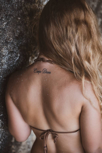 istock Carpe diem tattoo on young woman's back 1201021014