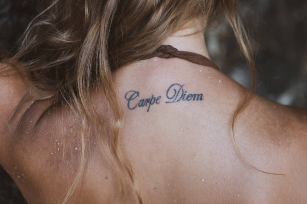 tatouage de carpe diem sur le dos de la jeune femme - latin motto photos et images de collection