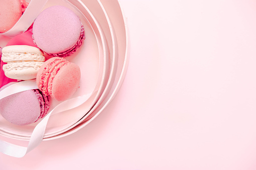 Valentine`s Day. Pink background with macaroons and ribbon.Soft pastel love. Flat lay, top view. Valentines Day