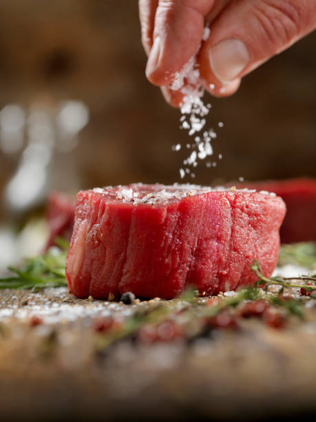 Seasoning Raw Fillet Mignon Steaks Seasoning Raw Fillet Mignon Steaks salt seasoning stock pictures, royalty-free photos & images