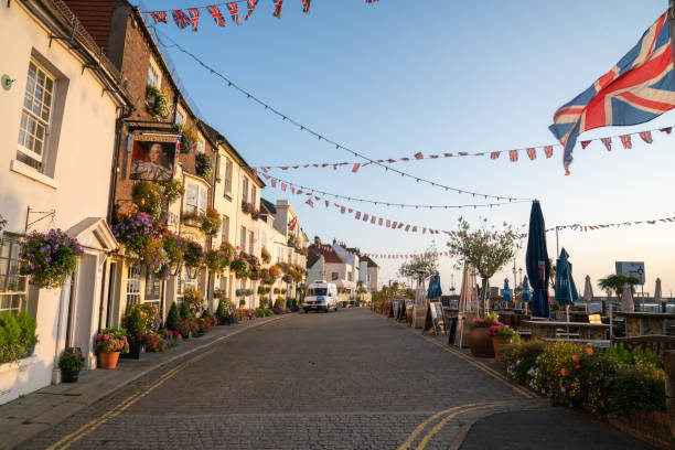 rua ao longo de pubs e restaurantes frontais com assentos ao ar livre e union jack voando - deal kent - fotografias e filmes do acervo