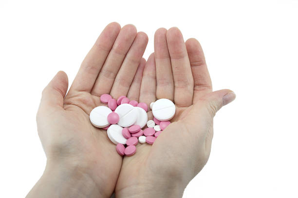 istock multicolored tablets of different size in hand top view close-up macro, isolated, white 1201024162