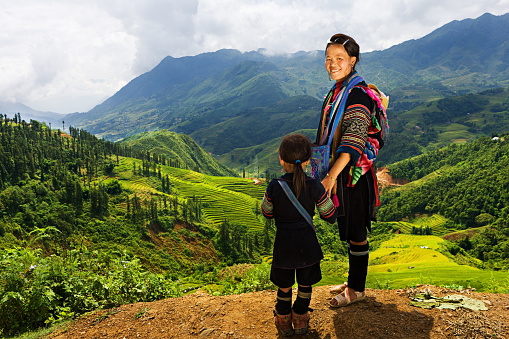 Black Hmong woman looking at the view & carrying her baby. Hmong Tribe is one of the largest ethnic minorities in Vietnam is the Hmong Tribe. They came from China, and now live in different regions of Vietnam.